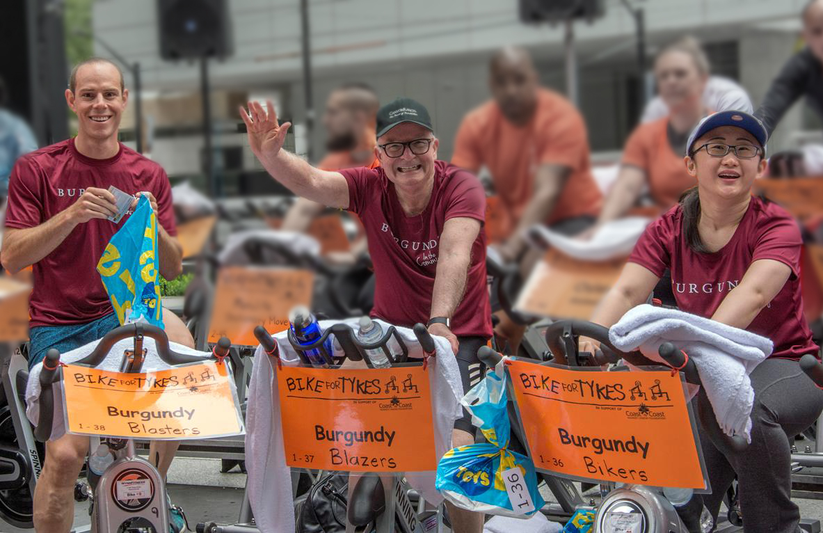 Three BAM employees on stationary bikes for a charity ride